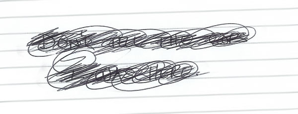 notebook paper showing writing which has been scribbled over with ballpoint pen