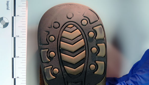 the bottom of a running shoe. The heel is worn down.