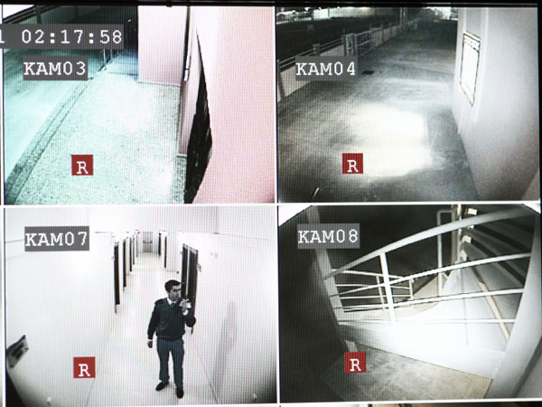 four video screens, from security cameras displaying portions of a warehouse