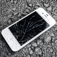 an iPhone with a broken screen lying on the ground
