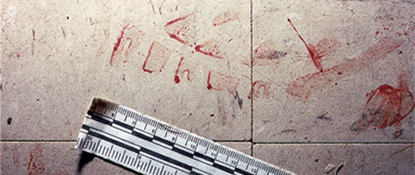 a bloody shoeprint on a tiled floor markes with a ruler