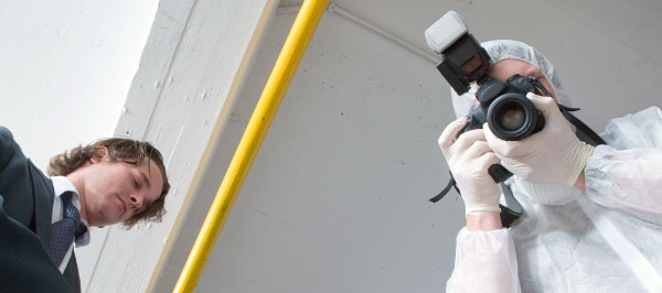 a photographer and detective working together on a crime scene